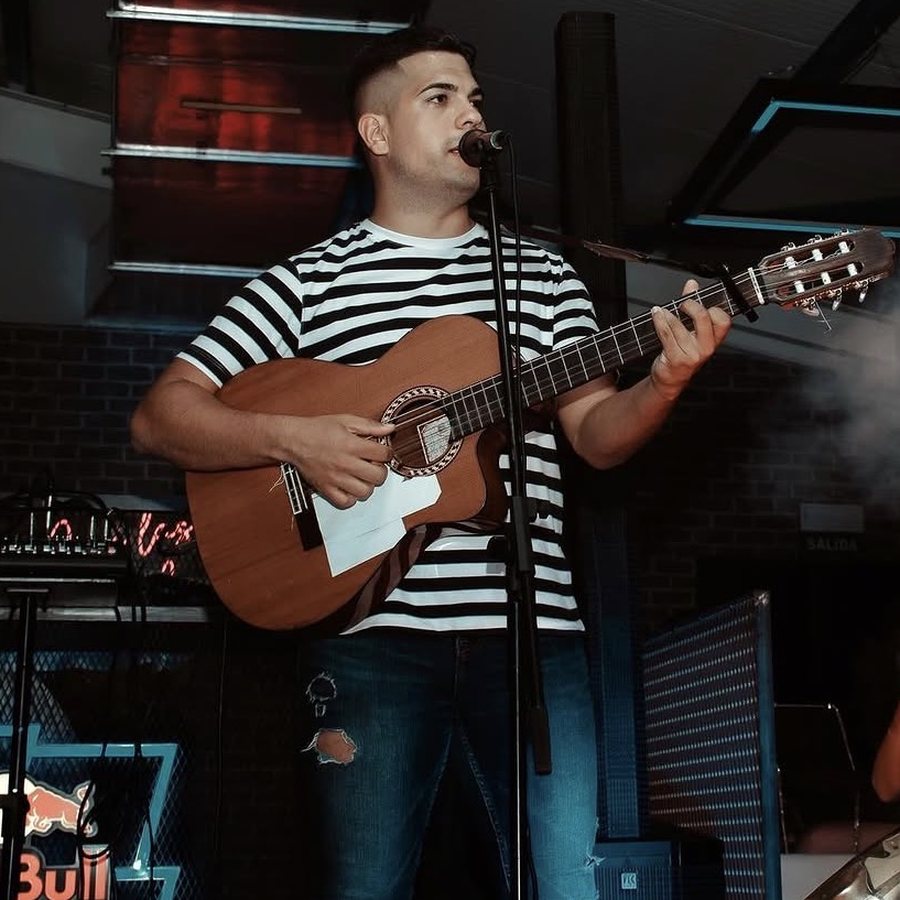 Pedro Afonso cantando con guitarra en directo